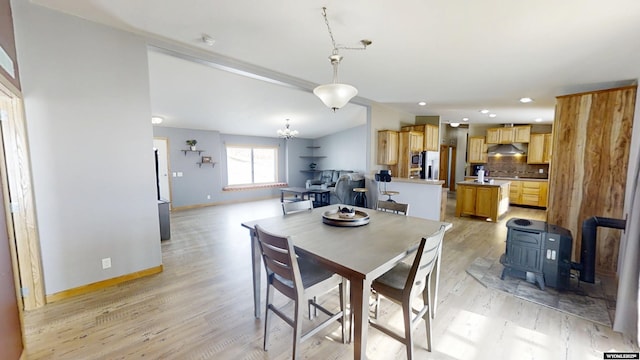 dining space with a notable chandelier, recessed lighting, light wood-style floors, baseboards, and vaulted ceiling