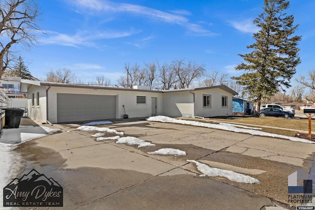 view of front of house with a garage, concrete driveway, and stucco siding