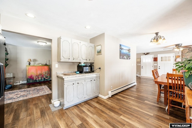 kitchen with white cabinetry, light countertops, light wood-style floors, and a baseboard radiator