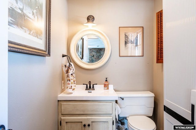 half bathroom with toilet and vanity