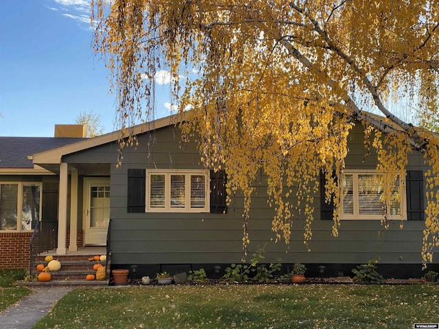 view of front of house with a front yard and roof with shingles