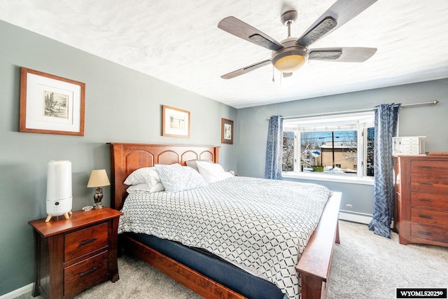 bedroom featuring a baseboard heating unit, carpet floors, a textured ceiling, and baseboards