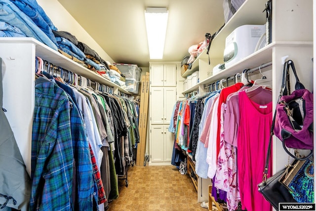 walk in closet with light floors