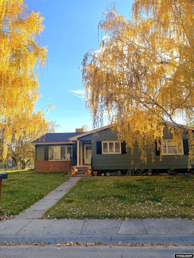 view of front of property featuring a front lawn and brick siding