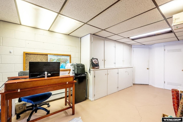 office with a drop ceiling, finished concrete flooring, and concrete block wall