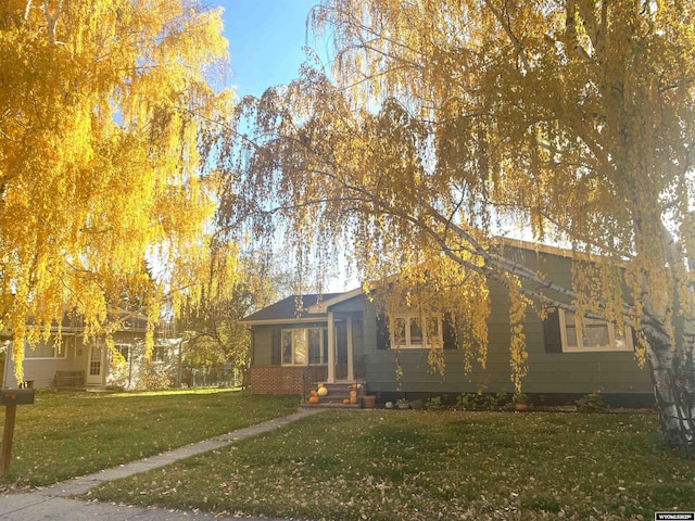 view of front of property featuring brick siding and a front lawn