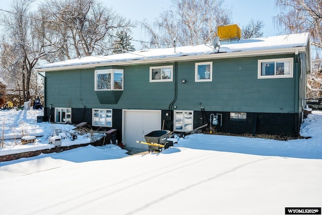 snow covered house with an attached garage