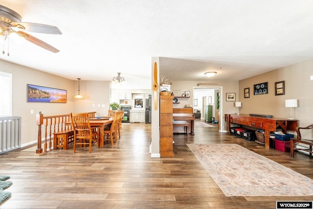 dining space featuring a ceiling fan, wood finished floors, and baseboards