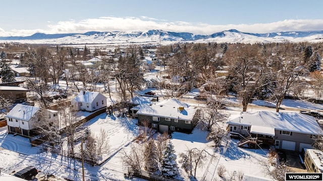 snowy aerial view with a mountain view and a residential view