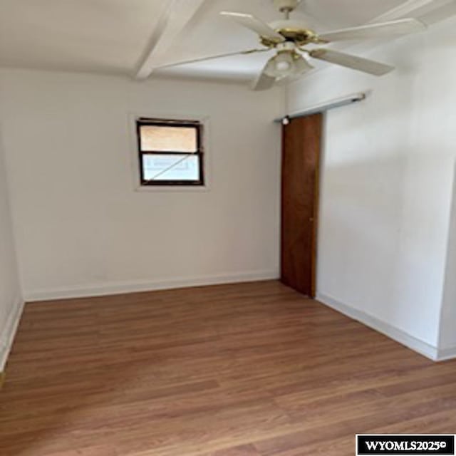 unfurnished room with light wood-style flooring, a ceiling fan, and baseboards