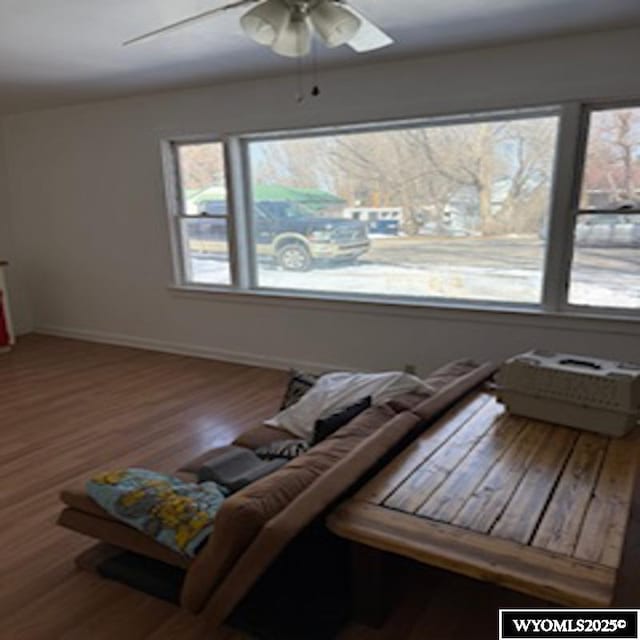 sitting room featuring a ceiling fan, wood finished floors, and baseboards