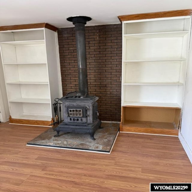 details with baseboards, wood finished floors, and a wood stove