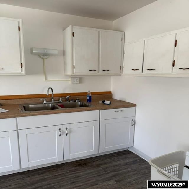 kitchen with dark wood-style floors, white cabinets, and a sink