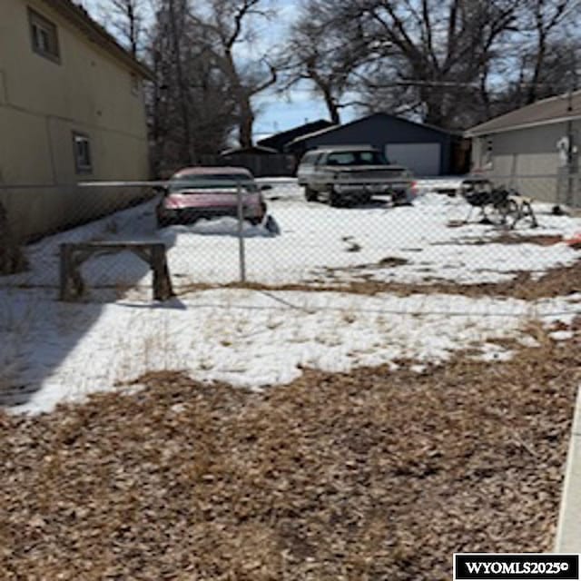 snowy yard with a garage