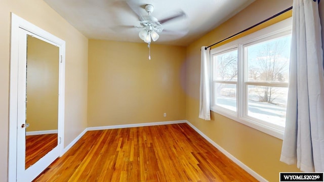 spare room featuring baseboards, light wood-style floors, and ceiling fan