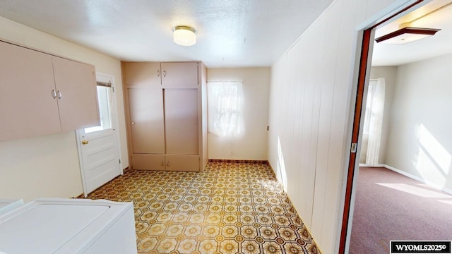 clothes washing area featuring baseboards, light floors, and laundry area