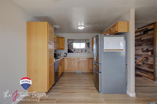 kitchen featuring wood finish floors, appliances with stainless steel finishes, light brown cabinets, and light countertops