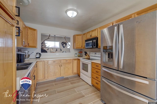 kitchen featuring light brown cabinetry, appliances with stainless steel finishes, light countertops, and wood tiled floor