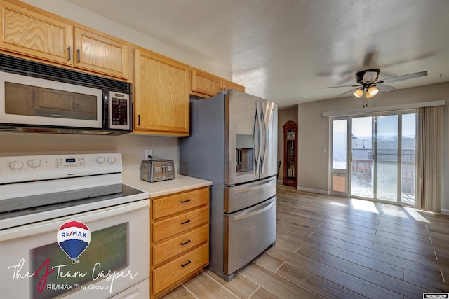 kitchen featuring wood finish floors, stainless steel refrigerator with ice dispenser, electric stove, light countertops, and baseboards