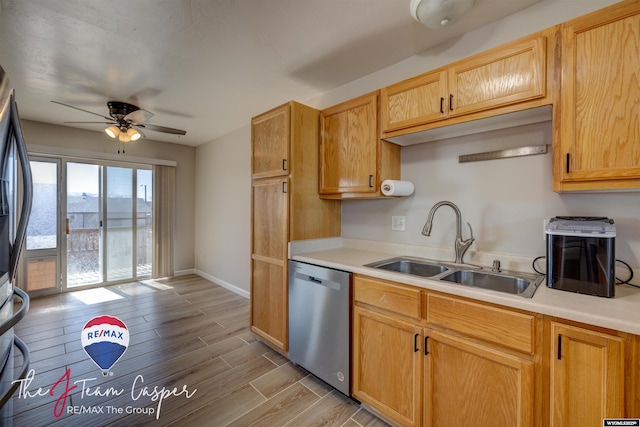 kitchen featuring dishwasher, wood tiled floor, light countertops, and a sink