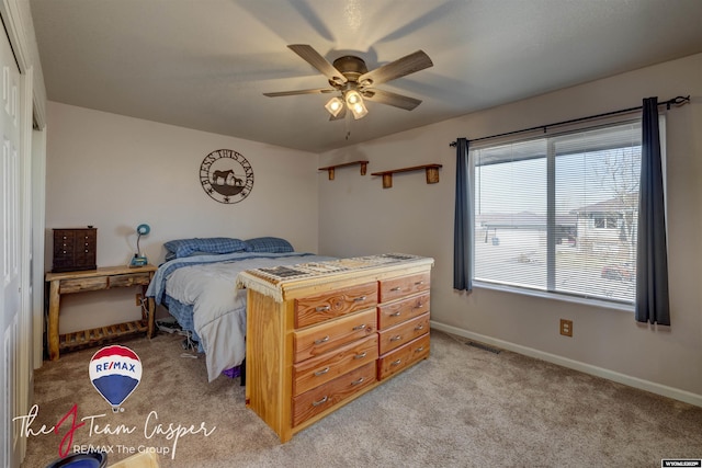 bedroom featuring light carpet, visible vents, a ceiling fan, and baseboards