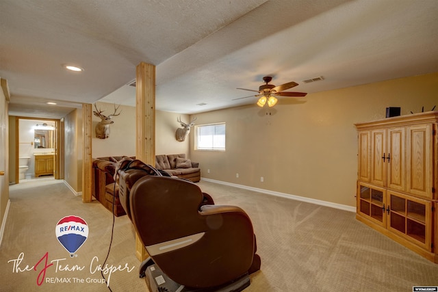 living area with visible vents, light carpet, a ceiling fan, a textured ceiling, and baseboards