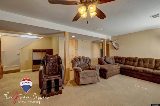 living area with a textured ceiling, ceiling fan, visible vents, and light carpet