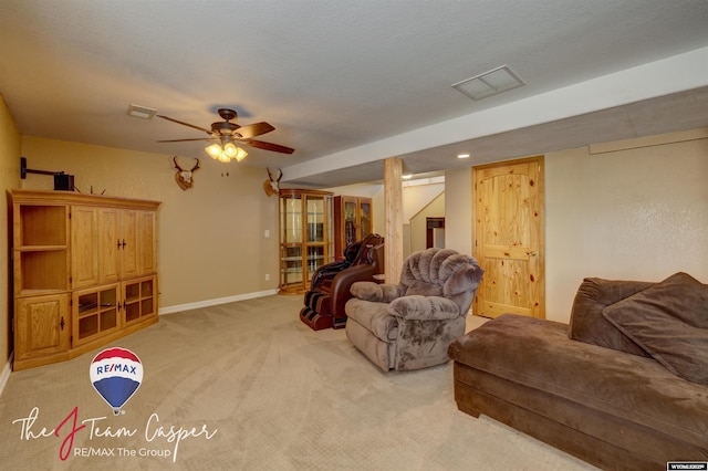 living area with a ceiling fan, visible vents, baseboards, and light carpet