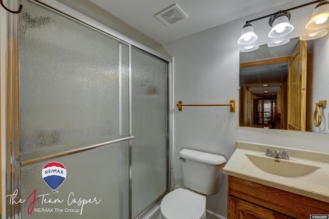 full bath with visible vents, toilet, a shower stall, and vanity