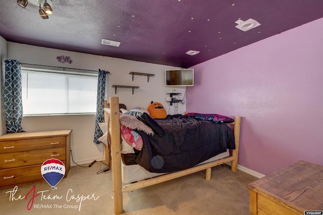 bedroom featuring baseboards, visible vents, a textured ceiling, and carpet