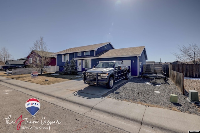 view of front facade with concrete driveway and fence