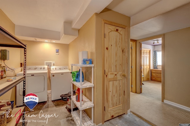 clothes washing area featuring laundry area, carpet, baseboards, and washer and clothes dryer