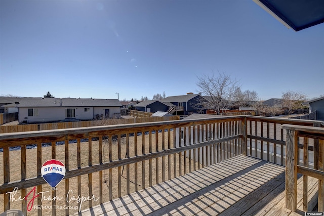 wooden deck with a residential view and a fenced backyard