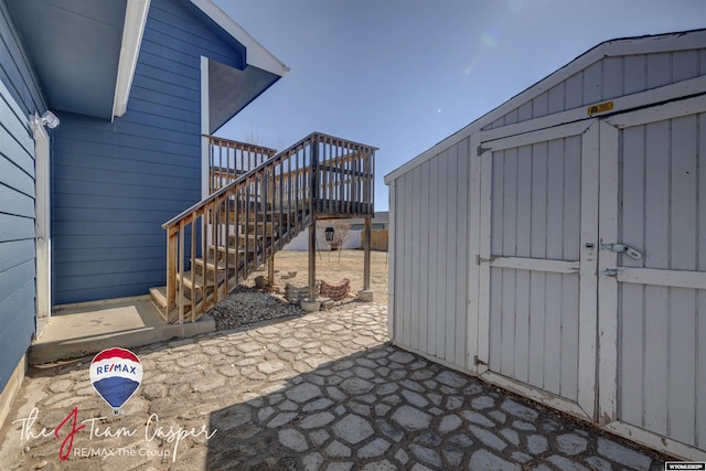 view of patio / terrace featuring stairway and an outdoor structure