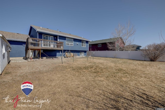 rear view of house with a deck and fence