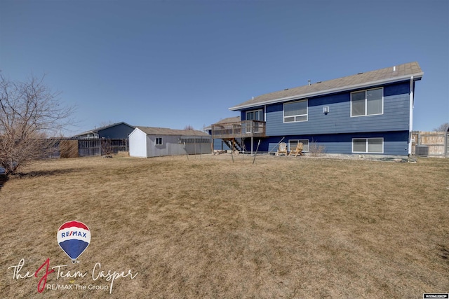 back of house featuring an outdoor structure, central air condition unit, a yard, and fence