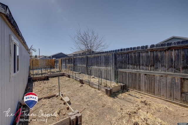 view of yard with a vegetable garden and a fenced backyard