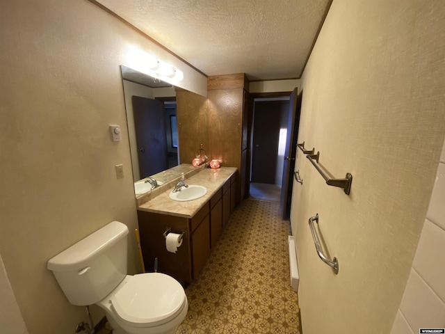 bathroom featuring vanity, tile patterned floors, toilet, and a textured ceiling