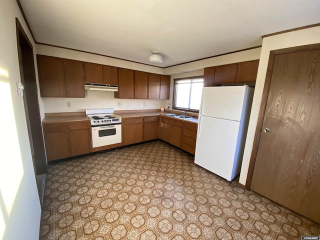 kitchen featuring crown molding, under cabinet range hood, light floors, white appliances, and a sink