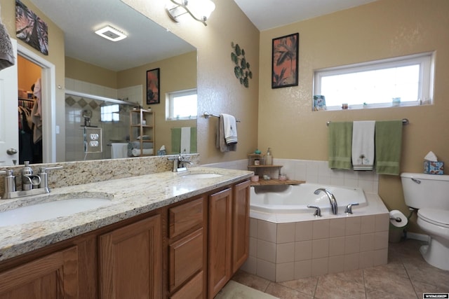 bathroom featuring a garden tub, toilet, a stall shower, and a sink