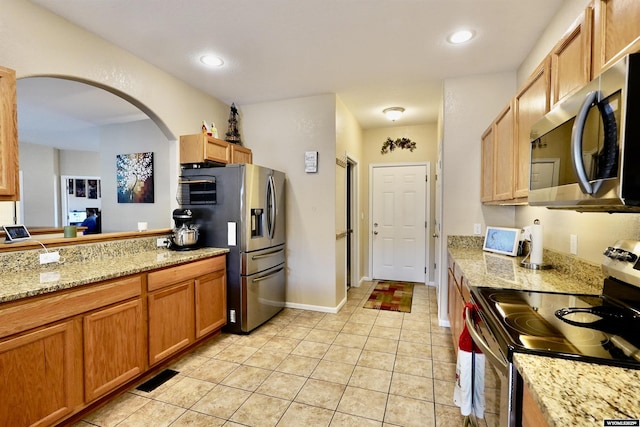 kitchen featuring light tile patterned floors, visible vents, recessed lighting, arched walkways, and appliances with stainless steel finishes