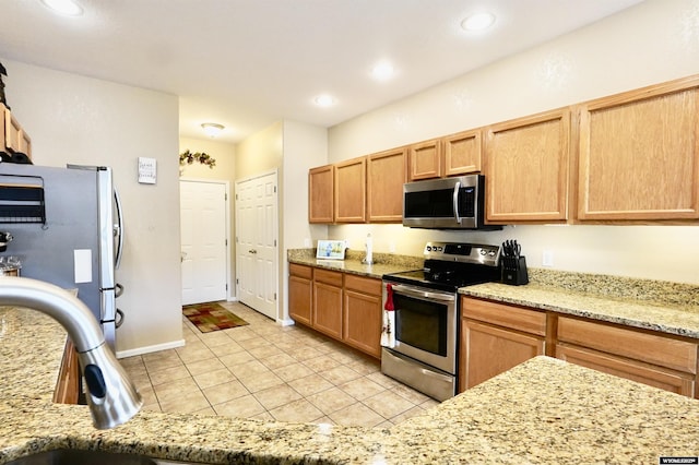 kitchen featuring light stone counters, light tile patterned floors, recessed lighting, and stainless steel appliances