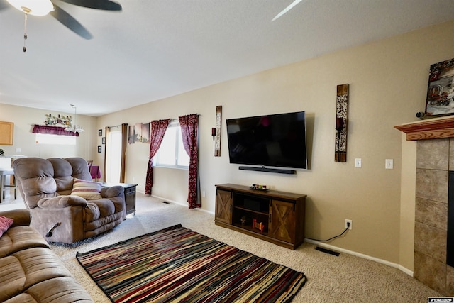 living room featuring a tiled fireplace, carpet, visible vents, and ceiling fan