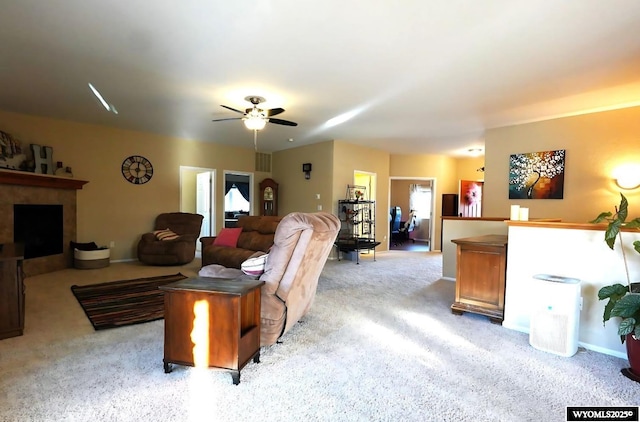 living room featuring light carpet, a fireplace, and ceiling fan