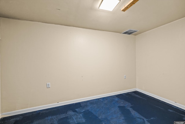 empty room featuring unfinished concrete floors, baseboards, and visible vents