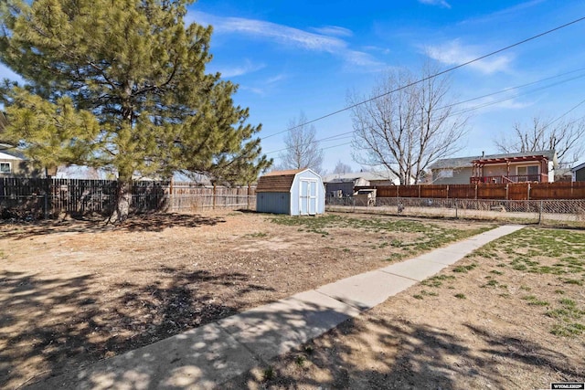 view of yard with an outbuilding, a storage shed, and a fenced backyard