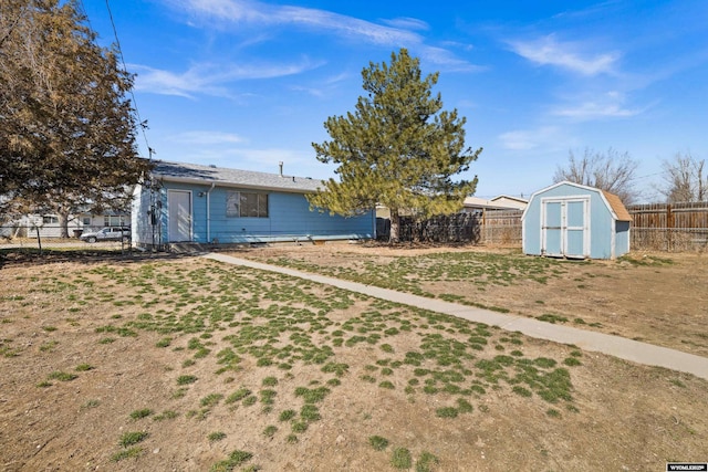 view of yard featuring a shed, an outdoor structure, and a fenced backyard