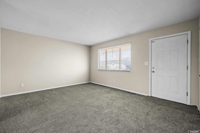 interior space with carpet flooring, baseboards, and a textured ceiling