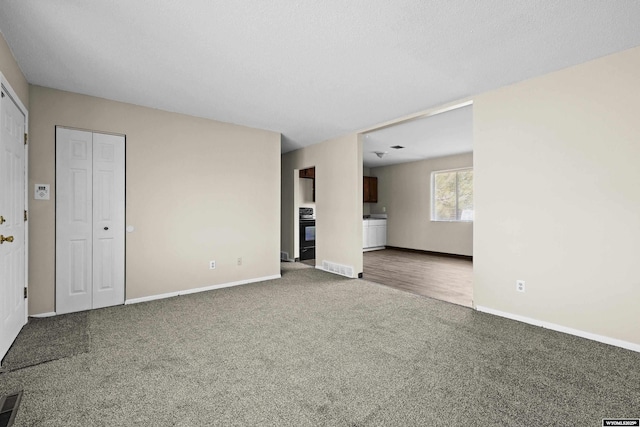 unfurnished living room featuring baseboards and carpet floors