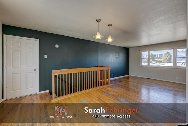 spare room with wood finished floors and baseboards